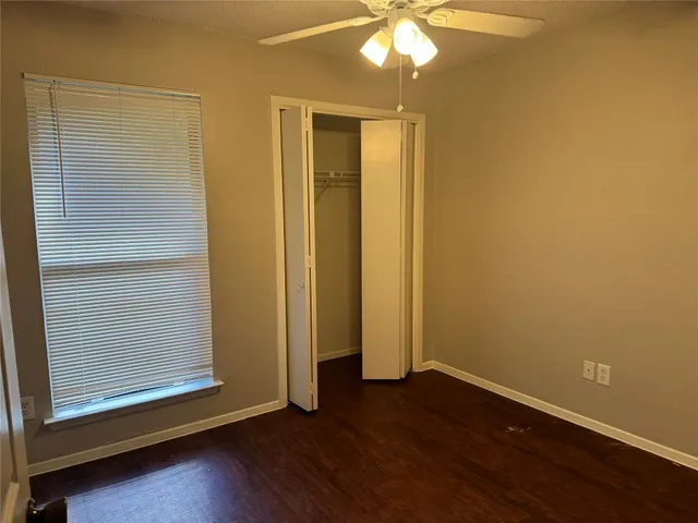 an empty room with wooden floor and closet area