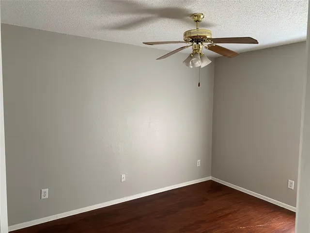 a view of a small space with wooden floor a ceiling fan and closet