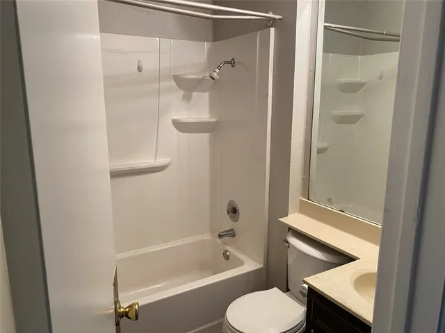 a bathroom with a tub shower sink and toilet