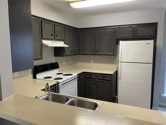 a kitchen with stainless steel appliances a refrigerator and a stove