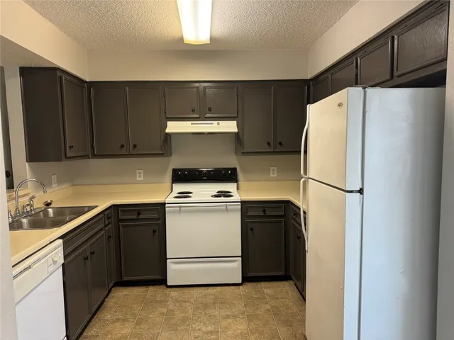 a kitchen with a refrigerator sink stove and cabinets