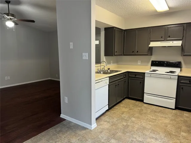 a kitchen with a stove sink and cabinets