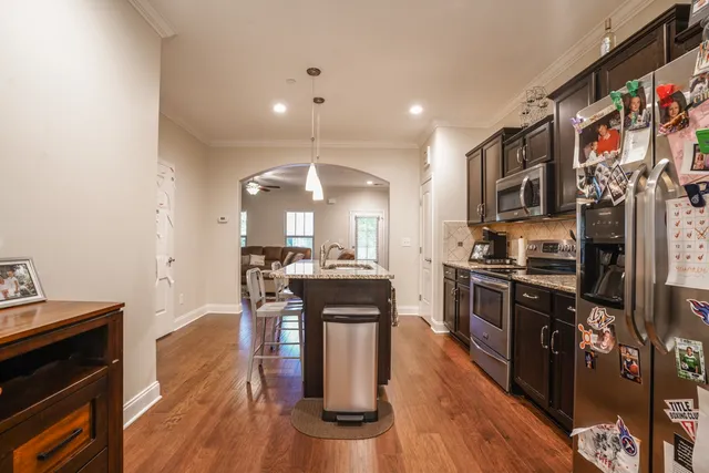 a dining room with wooden floor a chandelier a wooden table and chairs