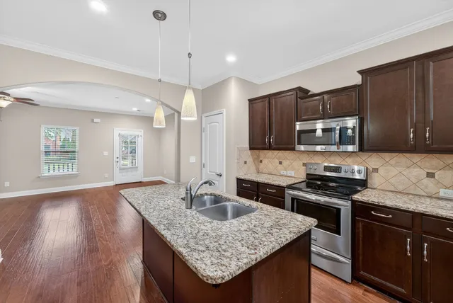 a view of a kitchen with a sink and refrigerator