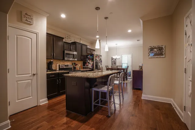 a kitchen with stainless steel appliances granite countertop a stove a sink and a microwave