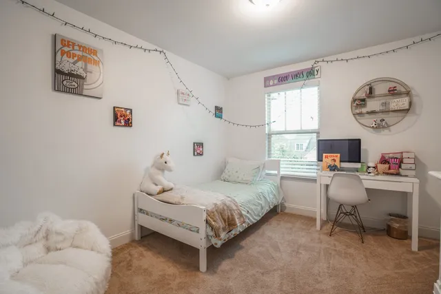 a bedroom with a bed a desk and chair next to a window