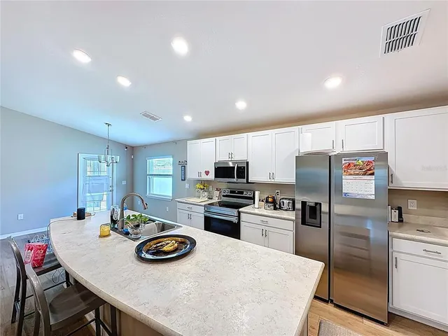 a kitchen with granite countertop a stove a sink and a microwave