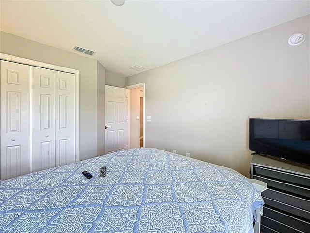 a bedroom with a large bed and flat screen tv