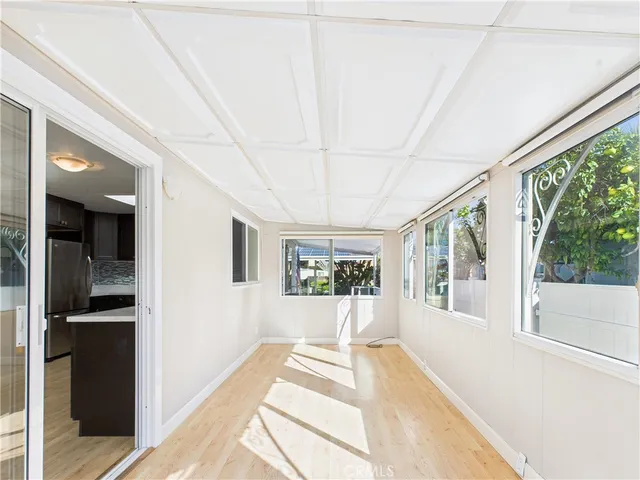 a view of a large room with wooden floor and windows