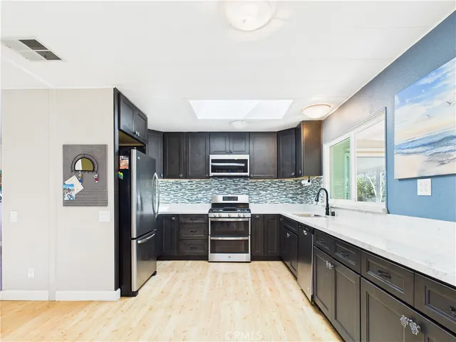 a kitchen with stainless steel appliances granite countertop a stove sink and refrigerator
