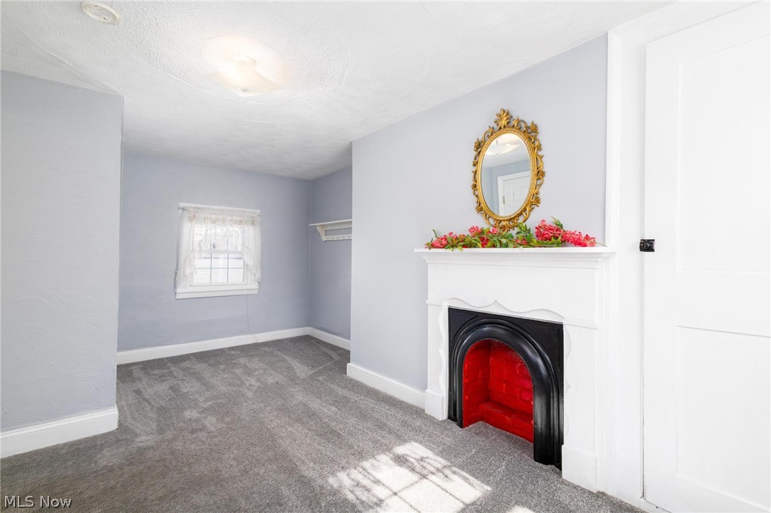 165 9th Street Wellsburg, WV 26070 - Photo 26 of 37 Unfurnished living room featuring carpet flooring, a fireplace, and a textured ceiling