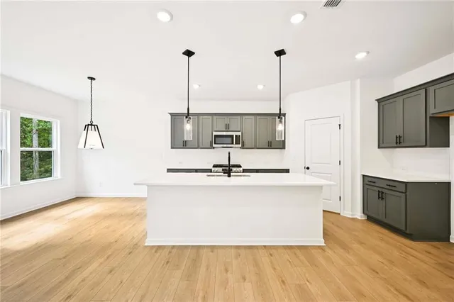 a kitchen with stainless steel appliances granite countertop a sink stove and microwave