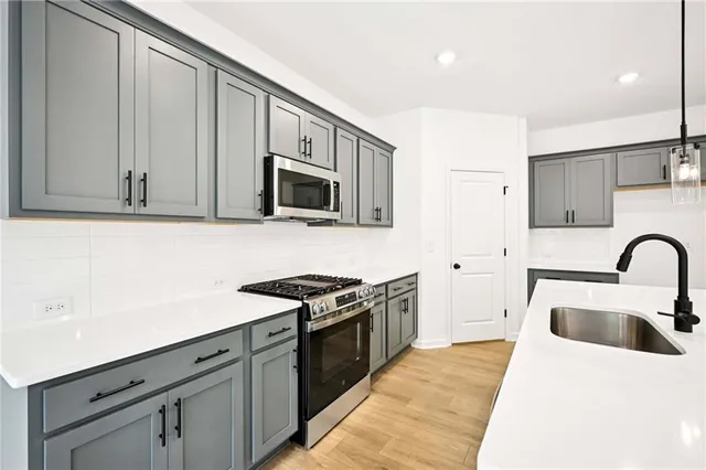 a kitchen with stainless steel appliances granite countertop a stove a sink and a microwave