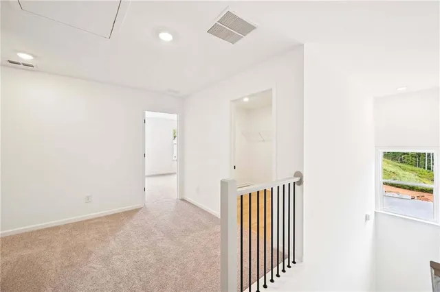 an empty room with windows and chandelier fan