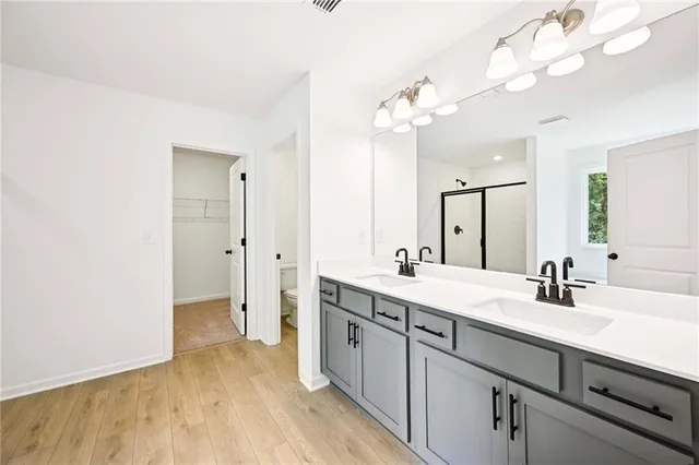 a spacious bathroom with a granite countertop sink a toilet and a mirror