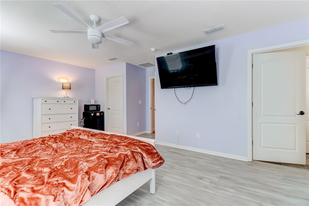 45170 Dutton Way Callahan, FL 32011 - Photo 17 of 35 a spacious bedroom with a bed and a flat screen tv