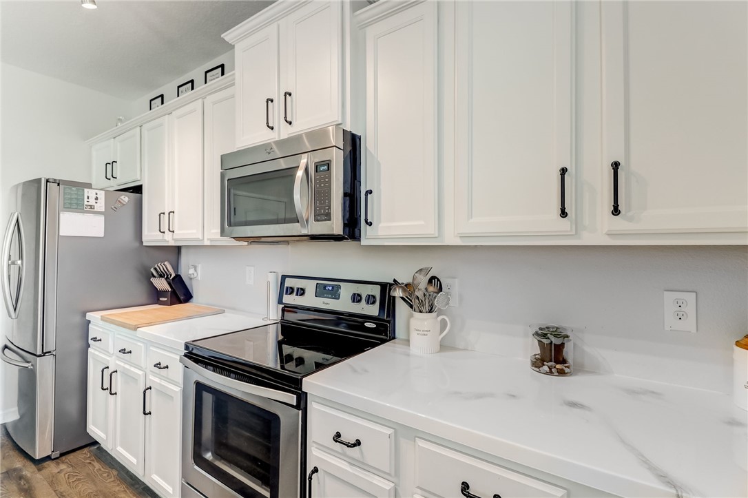 45170 Dutton Way Callahan, FL 32011 - Photo 10 of 35 a kitchen with stainless steel appliances granite countertop white cabinets sink and refrigerator