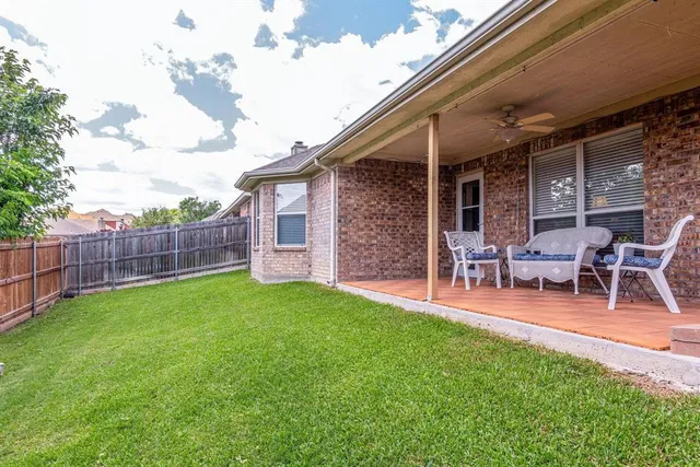 a backyard of a house with table and chairs