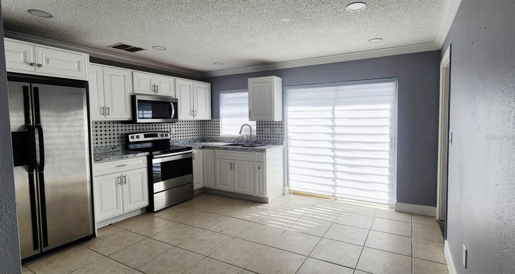 7118 Jenner Avenue New Port Richey, FL 34655 - Photo 3 of 12 a kitchen with a sink stainless steel appliances and cabinets