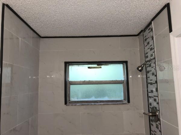 7118 Jenner Avenue New Port Richey, FL 34655 - Photo 7 of 12 a bathroom with a window and a shower