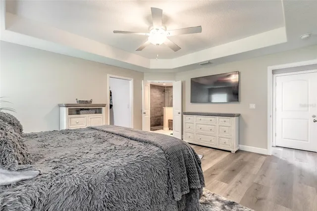 a bedroom with a large bed a flat tv screen and large dresser