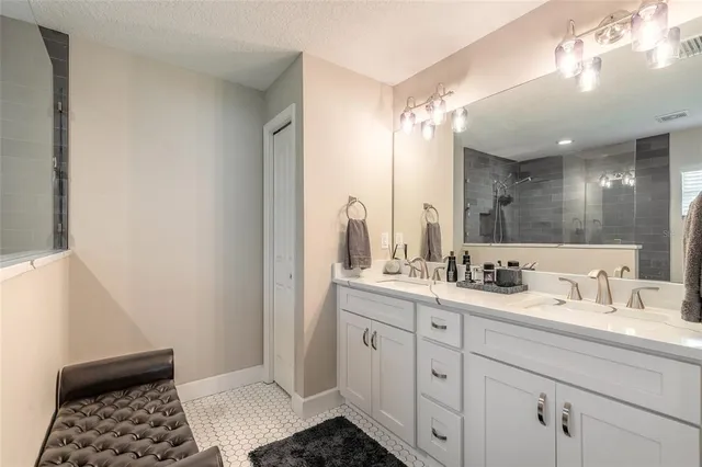 a bathroom with a double vanity sink a mirror and a shower