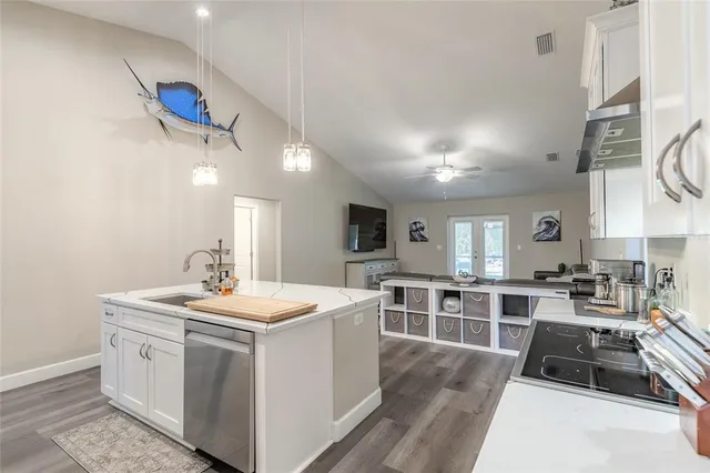 a kitchen that has a lot of cabinets in it and wooden floors