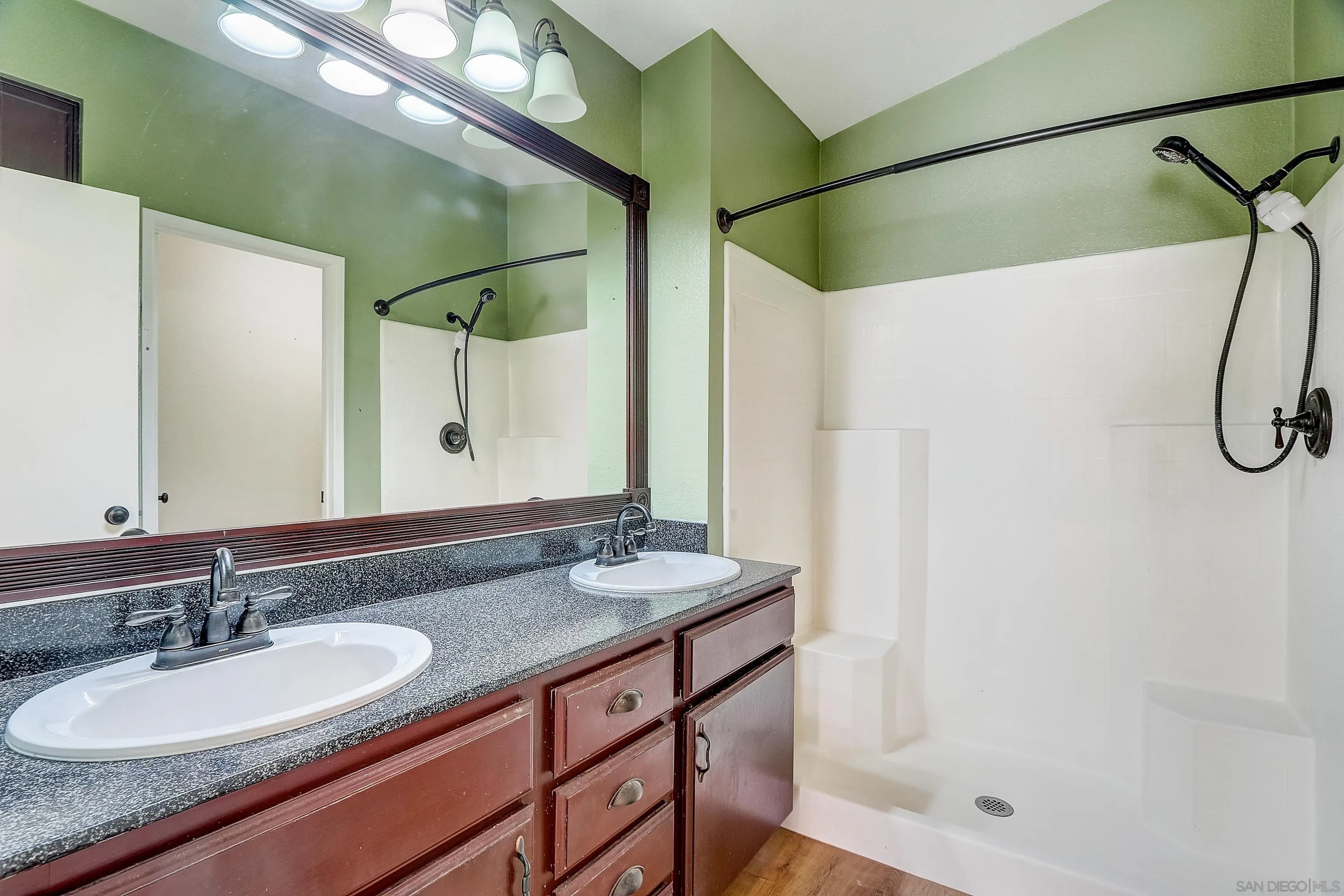 405 Ribbon Beach Way, Unit 249 Oceanside, CA 92058 - Photo 16 of 34 a bathroom with a granite countertop sink a mirror a vanity and shower