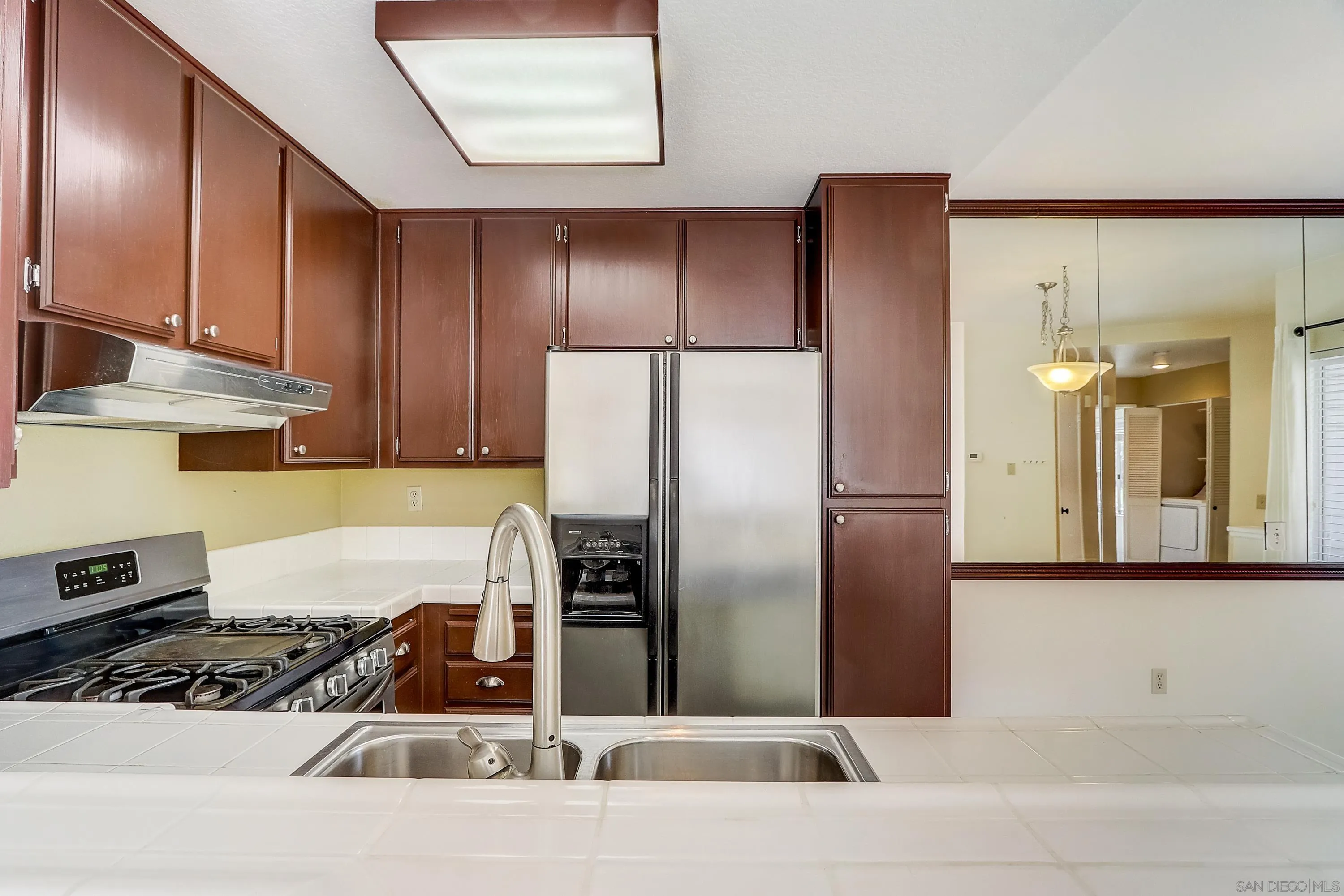 405 Ribbon Beach Way, Unit 249 Oceanside, CA 92058 - Photo 9 of 34 a kitchen with stainless steel appliances granite countertop a refrigerator and a stove