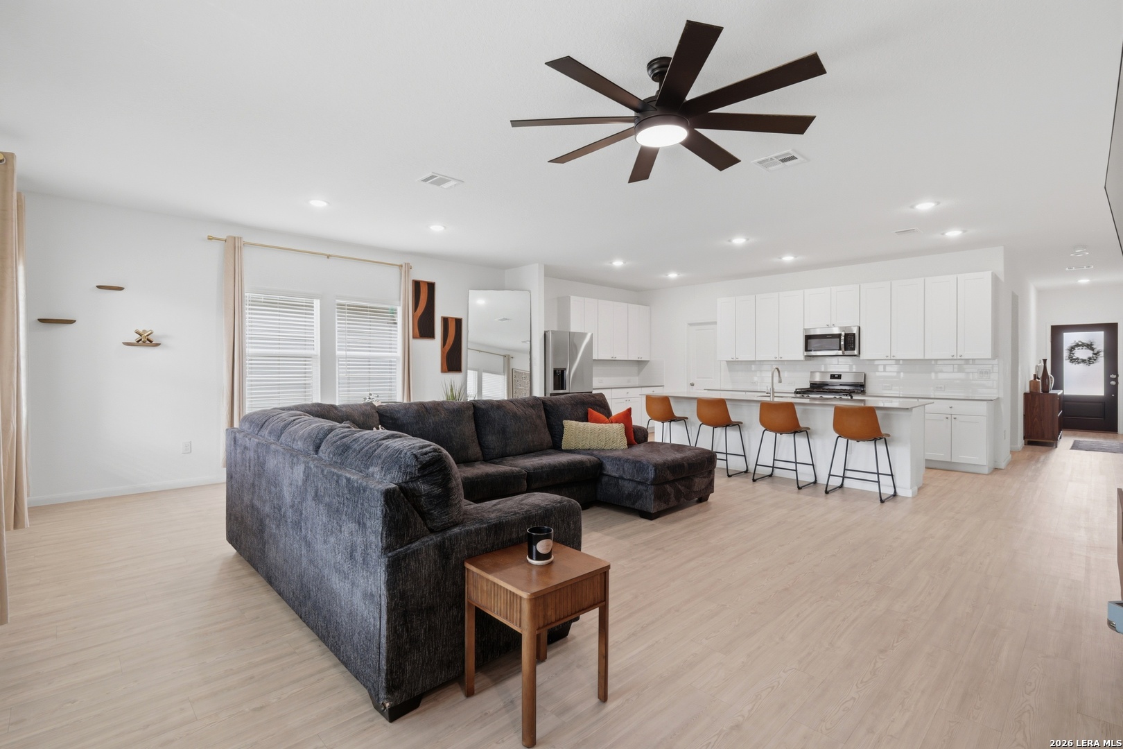 14919 Rhyolite Way Elmendorf, TX 78112 - Photo 9 of 26 a living room with furniture kitchen area and a wooden floor