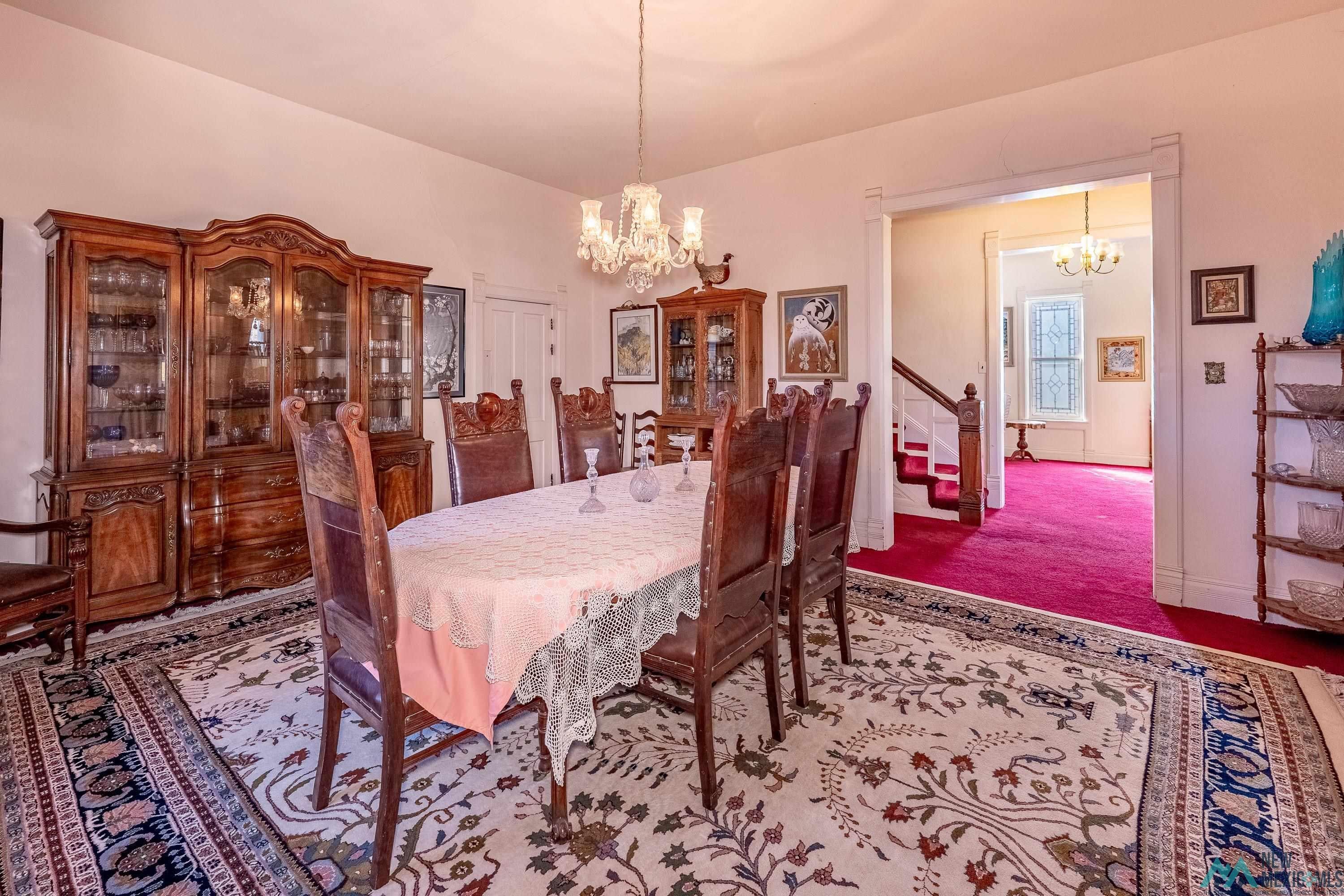 301 South 4th Street Raton, NM 87740 - Photo 8 of 78 Dining area featuring a chandelier, stairs, and carpet flooring