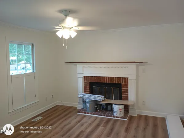 a living room with a fireplace and a ceiling fan