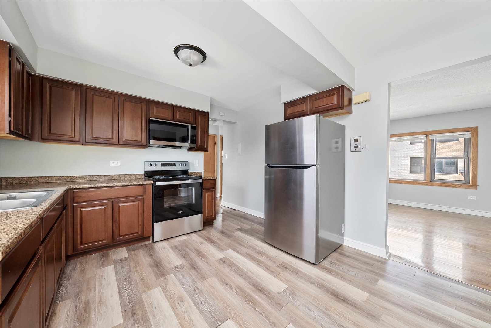 5701 West 55th Street, Unit 1S Chicago, IL 60638 - Photo 2 of 18 a kitchen with granite countertop a refrigerator and a stove top oven