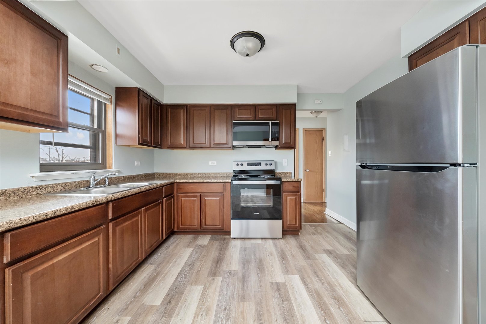 5701 West 55th Street, Unit 1S Chicago, IL 60638 - Photo 4 of 18 a kitchen with a refrigerator stove top oven and sink