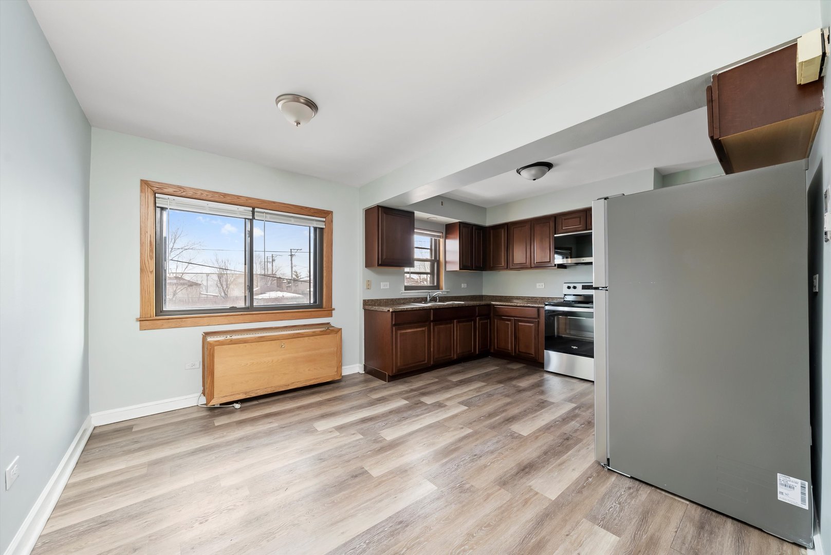 5701 West 55th Street, Unit 1S Chicago, IL 60638 - Photo 5 of 18 a kitchen with stainless steel appliances a refrigerator a sink dishwasher with a dining table and chairs