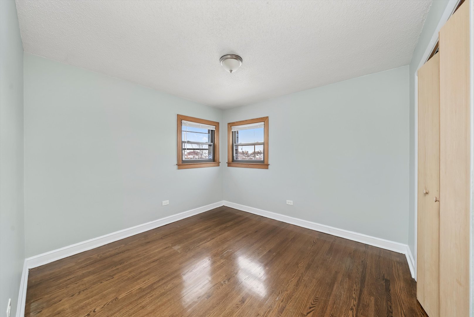 5701 West 55th Street, Unit 1S Chicago, IL 60638 - Photo 8 of 18 an empty room with wooden floor and windows
