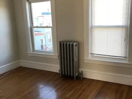 an empty room with wooden floor and a window