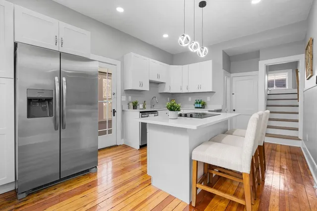 a kitchen with a stove cabinets and wooden floor