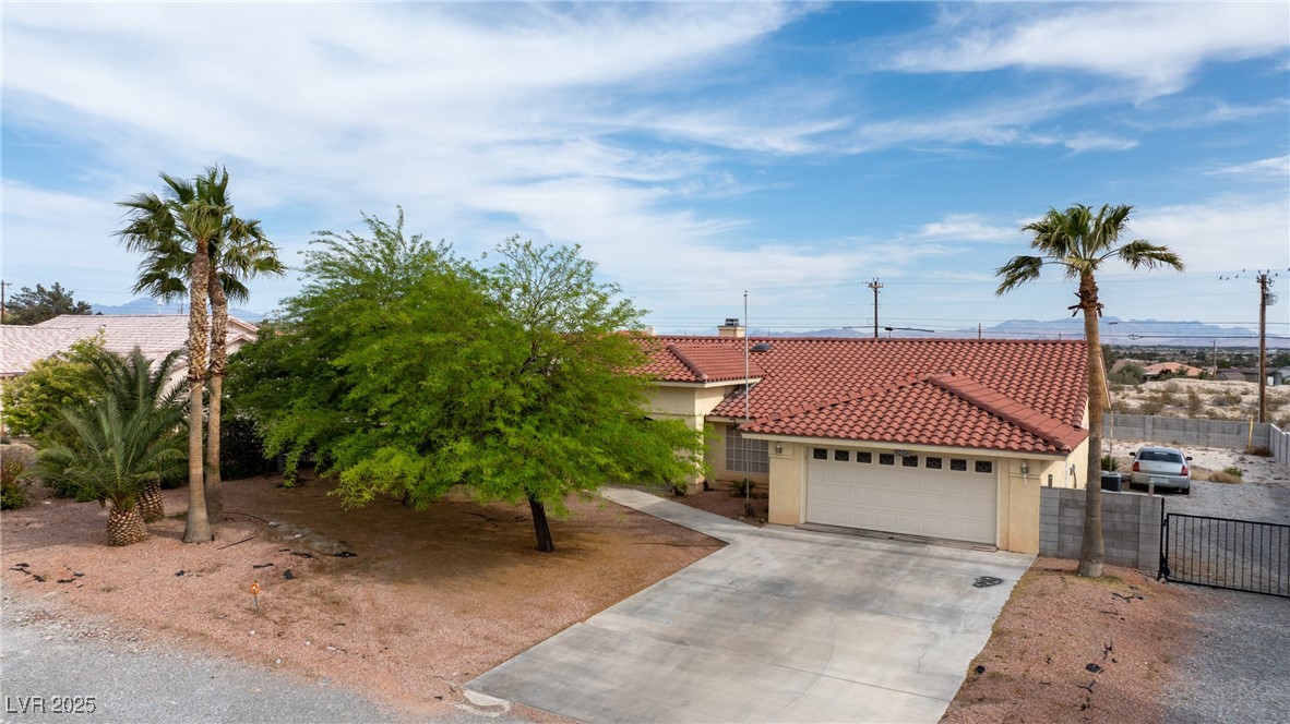 3481 Winery Road Pahrump, NV 89048 - Photo 2 of 34 View of front of property with a tile roof, stucco siding, driveway, and a garage