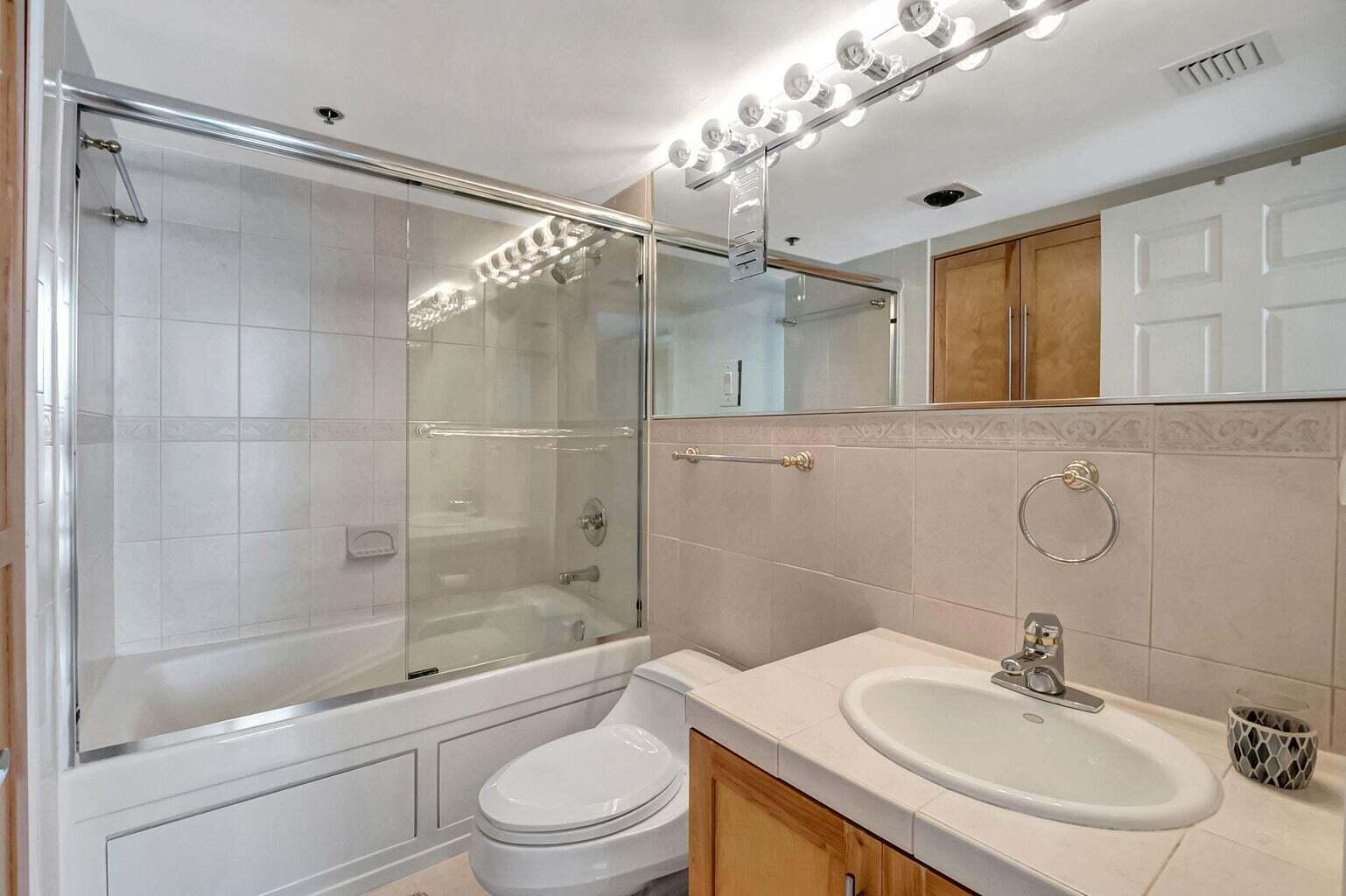 2707 North Ocean Boulevard, Unit D205 Boca Raton, FL 33431 - Photo 29 of 51 a bathroom with a sink vanity granite toilet and shower