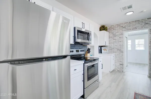 a kitchen with stainless steel appliances a refrigerator a stove a microwave and cabinets