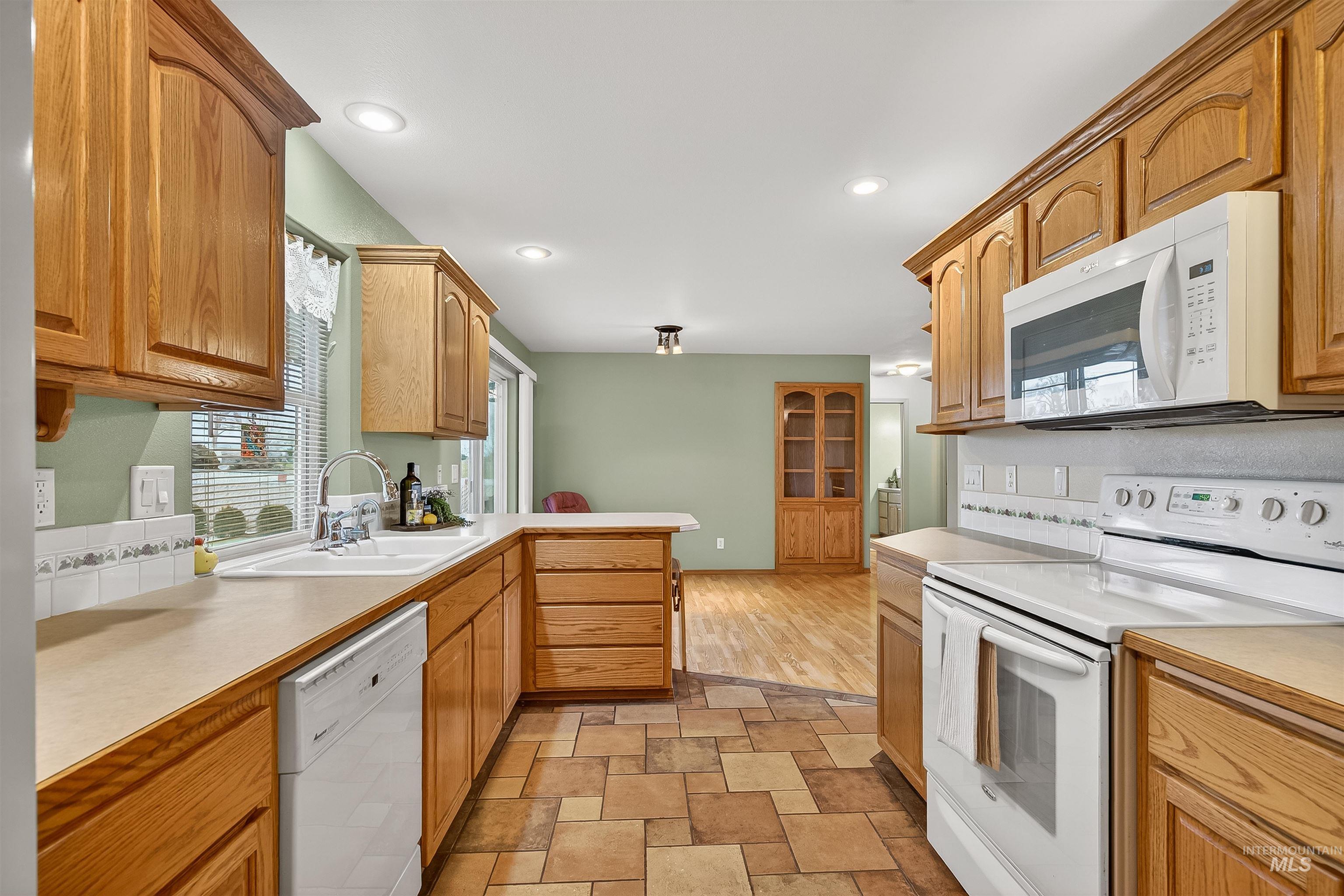 1324 Setlow Court Clarkston, WA 99403 - Photo 11 of 49 Kitchen featuring white appliances, light countertops, stone finish flooring, and recessed lighting