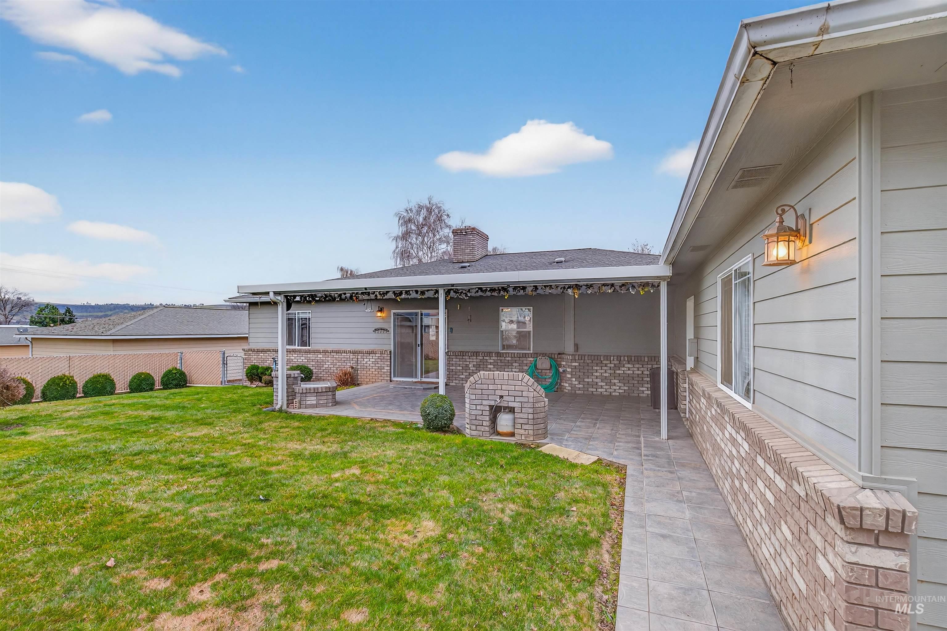 1324 Setlow Court Clarkston, WA 99403 - Photo 36 of 49 Rear view of house with brick siding, a chimney, and a patio