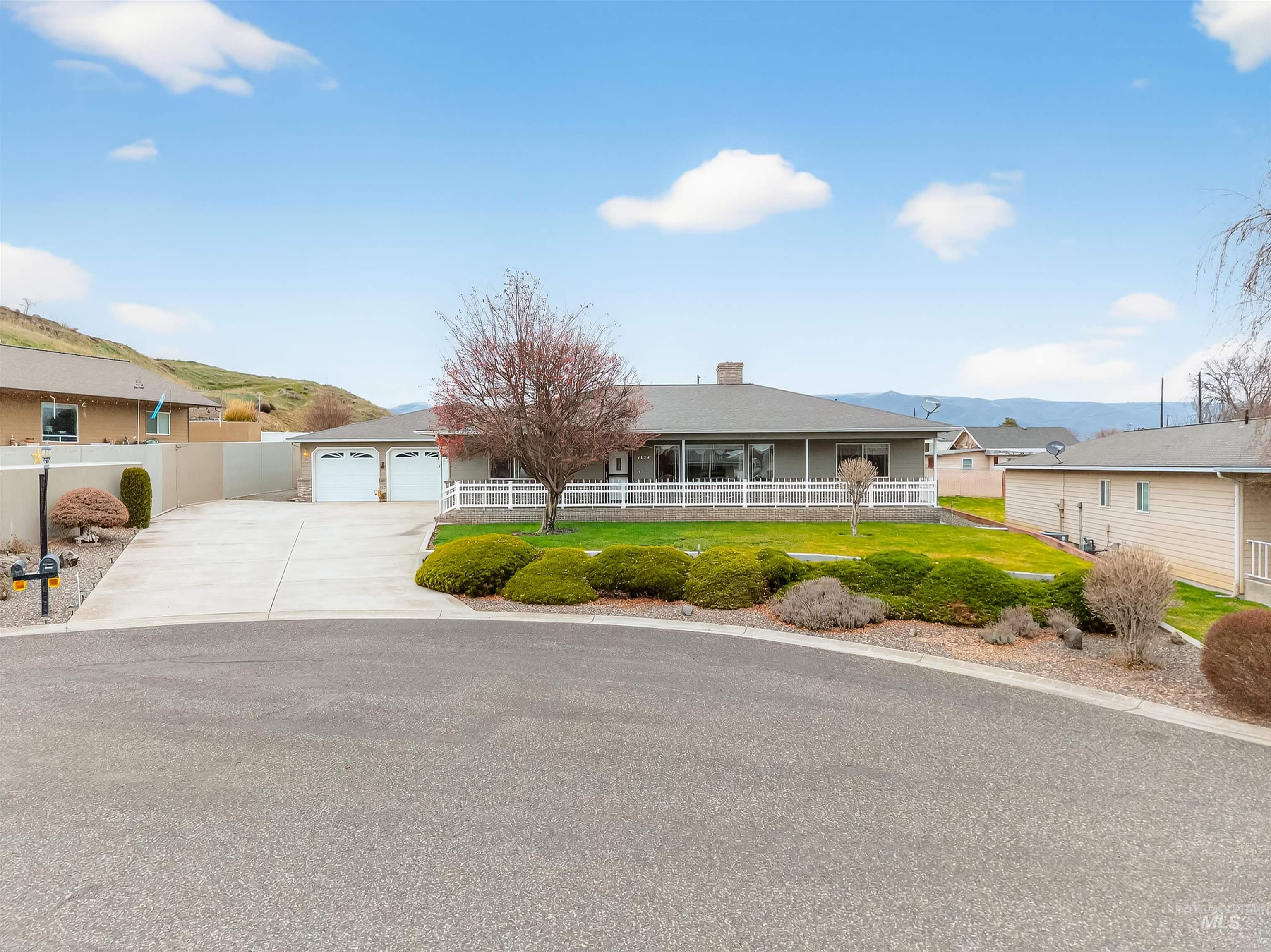 1324 Setlow Court Clarkston, WA 99403 - Photo 48 of 49 View of front of home with a mountain view, driveway, a garage, a chimney, and covered porch