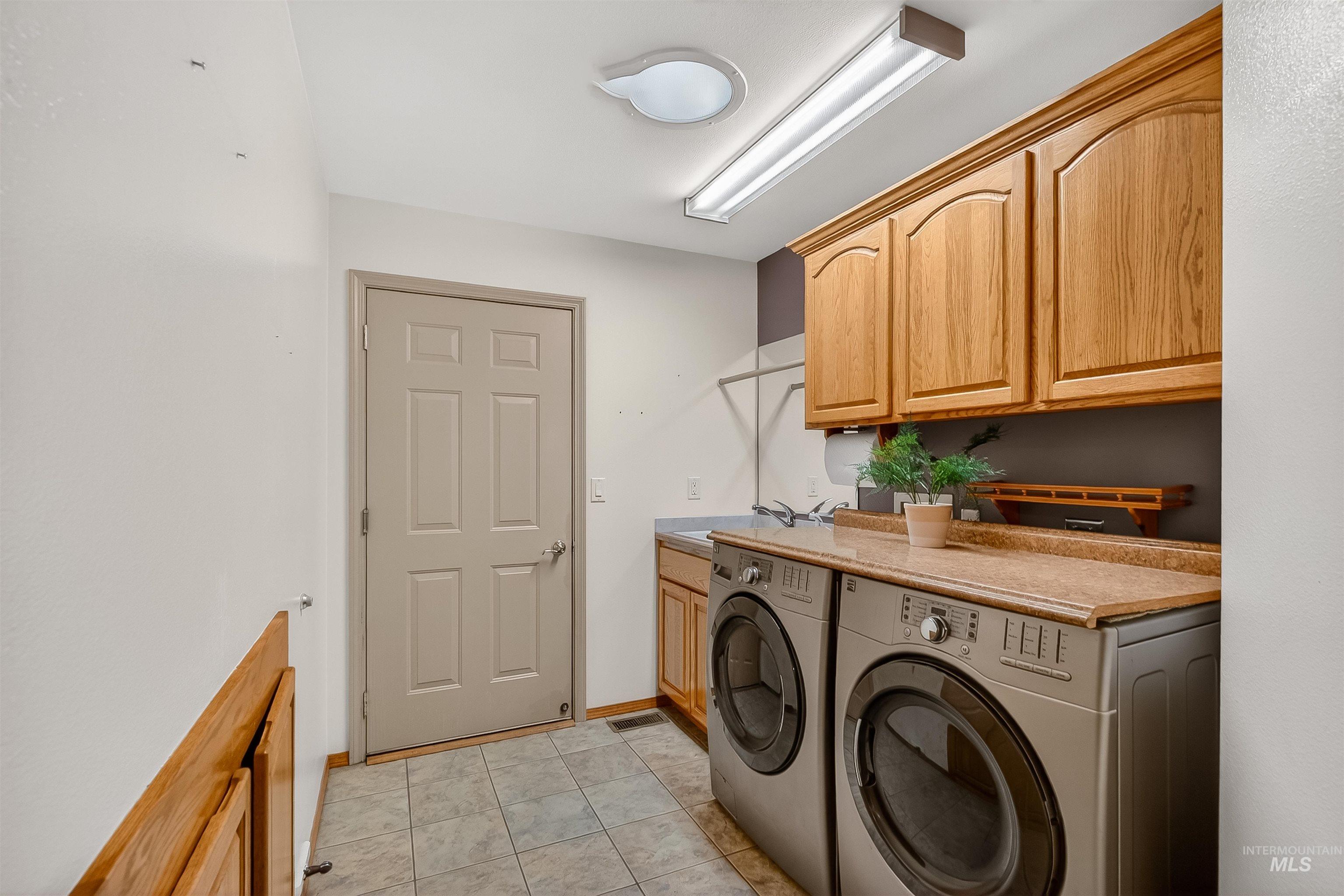 1324 Setlow Court Clarkston, WA 99403 - Photo 9 of 49 Laundry room featuring cabinet space, separate washer and dryer, and light tile patterned floors