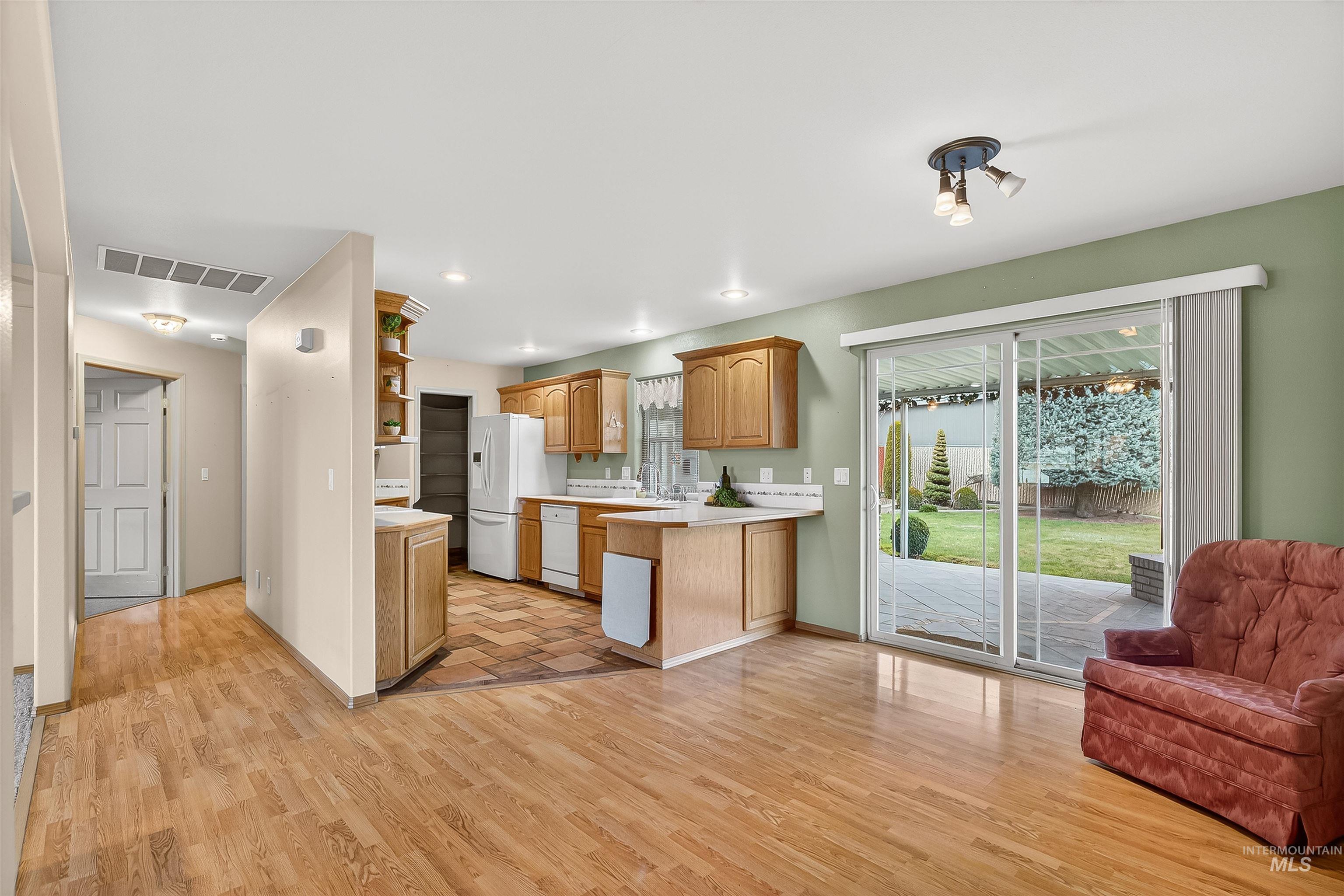 1324 Setlow Court Clarkston, WA 99403 - Photo 49 of 49 Kitchen with light countertops, open shelves, light wood-style flooring, white dishwasher, and open floor plan