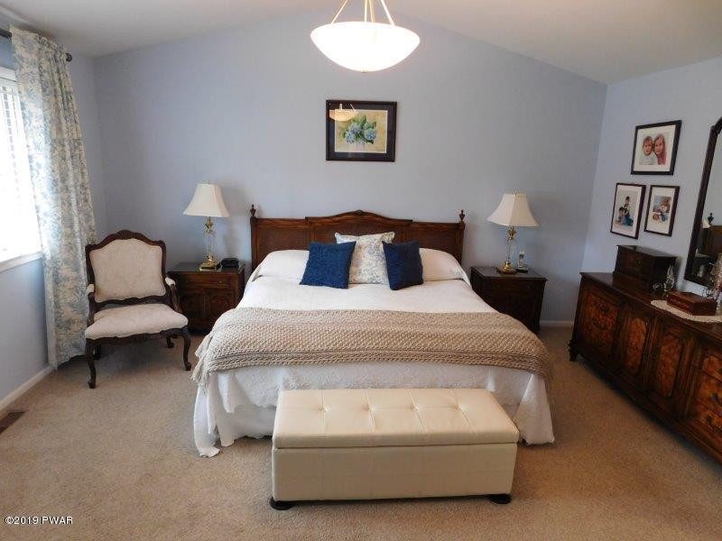 102 Rodeo Lane Hawley, PA 18428 - Photo 19 of 52 a spacious bedroom with bed and a couch