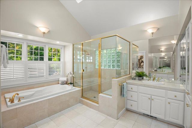 a spacious bathroom with a tub sink shower and mirror