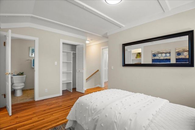 a bedroom with a bed and painting on the wall