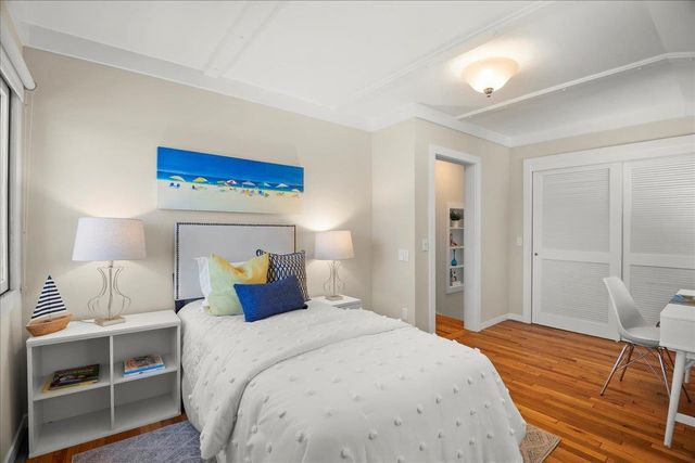 a bedroom with a bed and a lamp on dresser